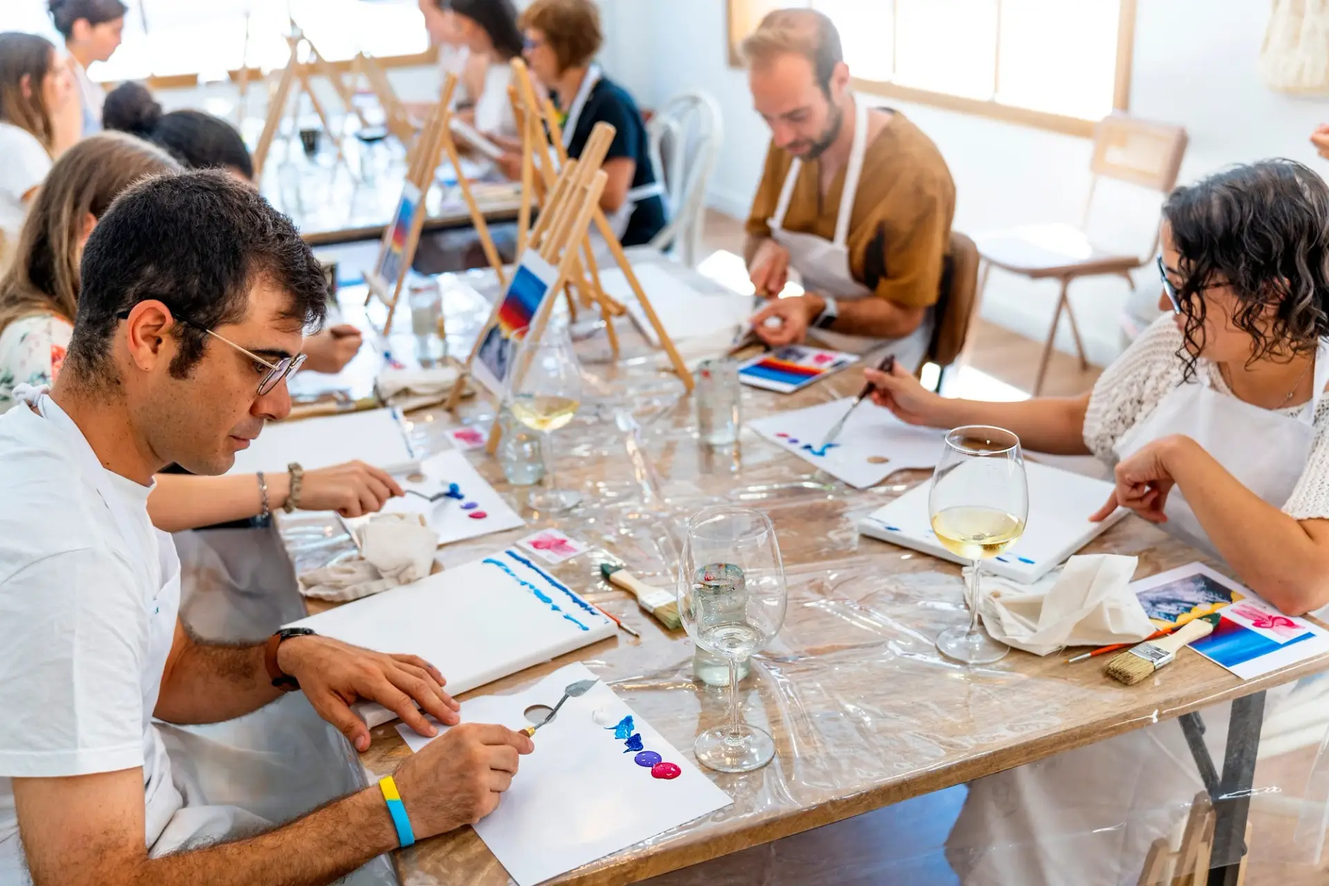 Art and Wine Workshop. Group of friends painting and drinking wine.